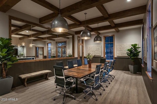 dining space featuring wood finished floors, wainscoting, coffered ceiling, and beam ceiling