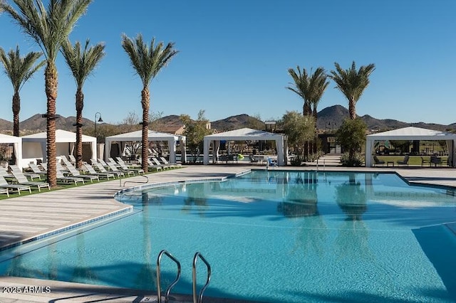 view of swimming pool with a mountain view and a gazebo