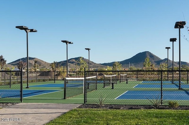 view of sport court with fence and a mountain view