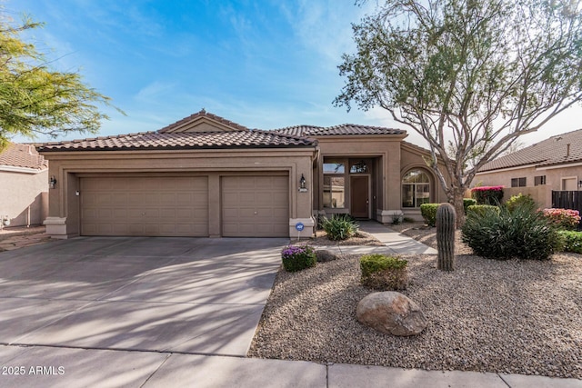 mediterranean / spanish house with stucco siding, a garage, driveway, and a tiled roof