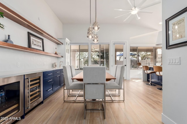 dining space with wine cooler, light wood-type flooring, and indoor bar