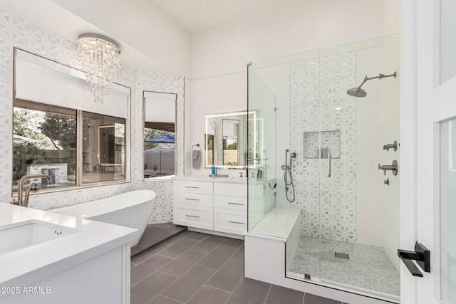 full bathroom featuring vanity, a freestanding bath, walk in shower, tile patterned floors, and a chandelier