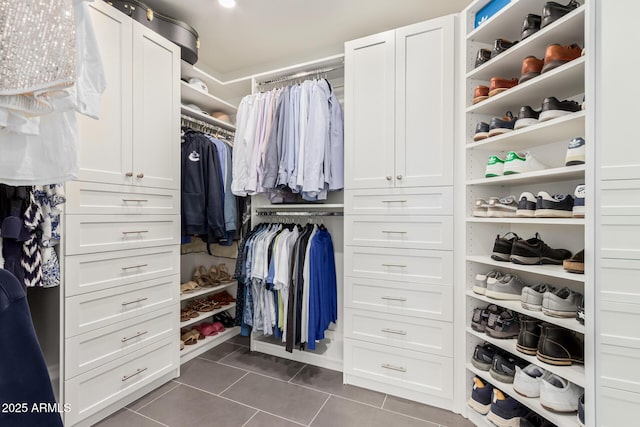 walk in closet featuring dark tile patterned flooring