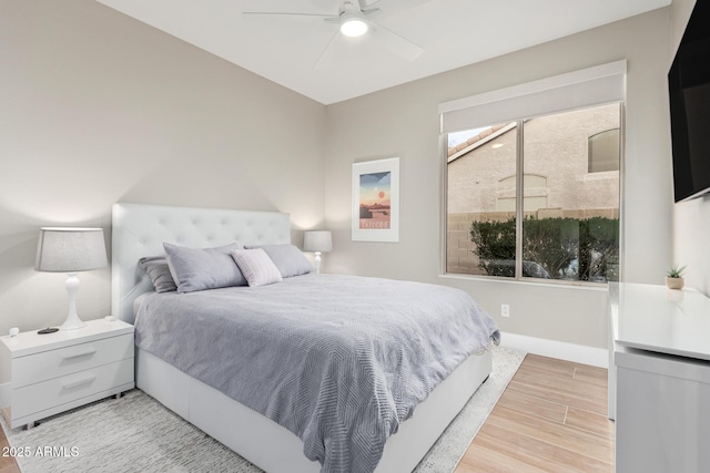 bedroom featuring ceiling fan, baseboards, and light wood-style flooring