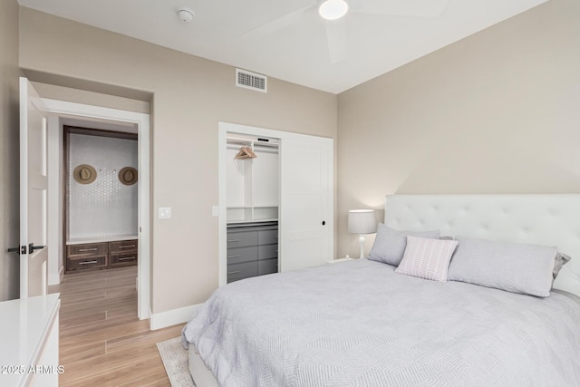 bedroom with visible vents, a closet, light wood-style floors, baseboards, and ceiling fan