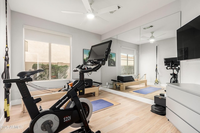 workout area with visible vents, baseboards, wood finished floors, and a ceiling fan