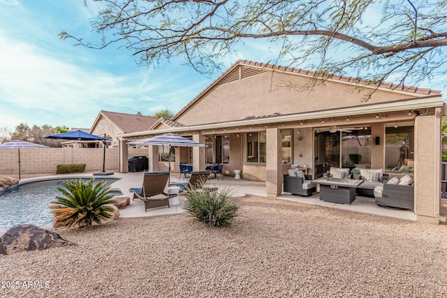 back of house with stucco siding, a patio, outdoor lounge area, and fence