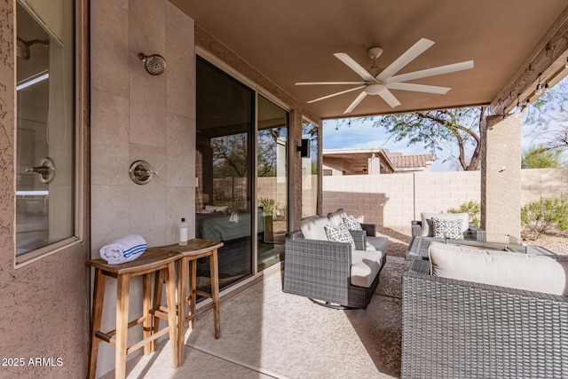 view of patio featuring outdoor lounge area, fence, and a ceiling fan