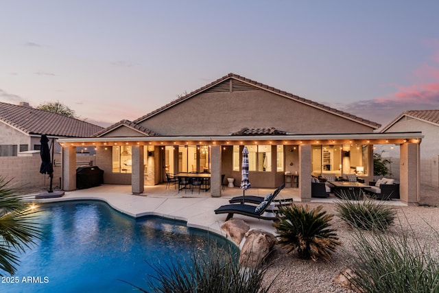 pool at dusk with an outdoor living space, fence, a fenced in pool, and a patio area