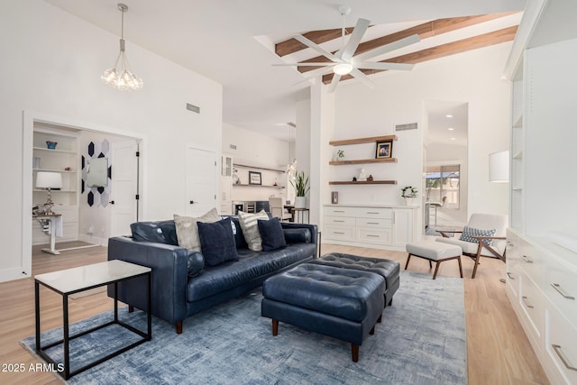 living area featuring light wood-type flooring, beam ceiling, high vaulted ceiling, and visible vents