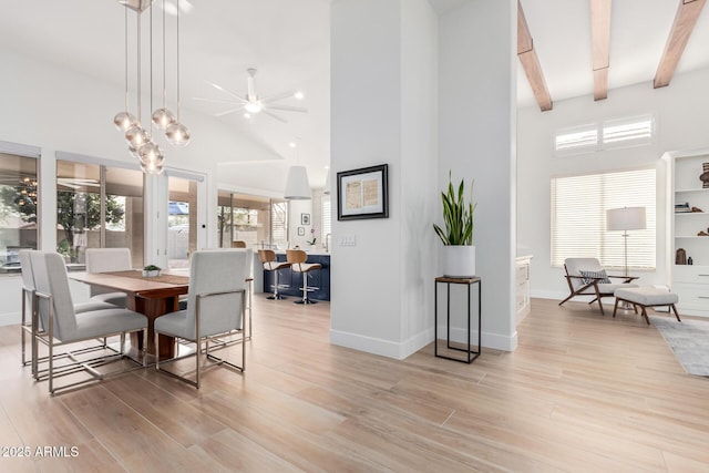 dining space with light wood finished floors, a wealth of natural light, and high vaulted ceiling