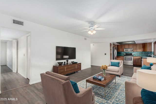 living room featuring ceiling fan, dark hardwood / wood-style flooring, and sink