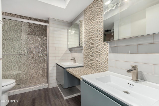 bathroom featuring decorative backsplash, tile walls, wood-type flooring, and walk in shower