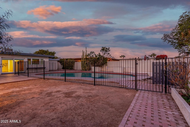 pool at dusk featuring a patio area