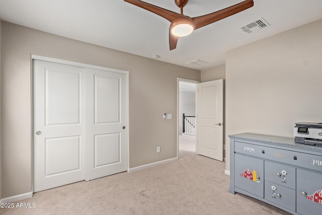 unfurnished bedroom with light colored carpet, a closet, and ceiling fan