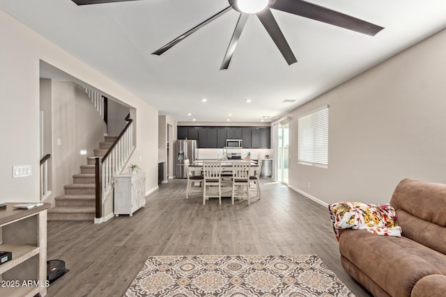 living room featuring wood-type flooring and ceiling fan