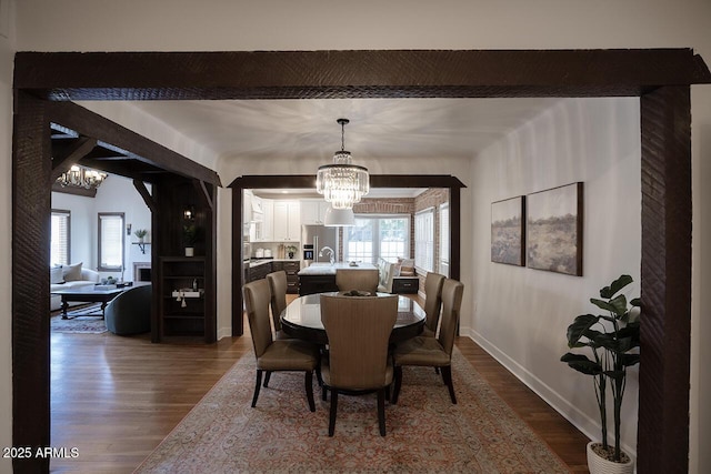 921 W Willetta St, Phoenix, AZ 85007 - dining area with a chandelier, dark wood-type flooring, baseboards, and beam ceiling