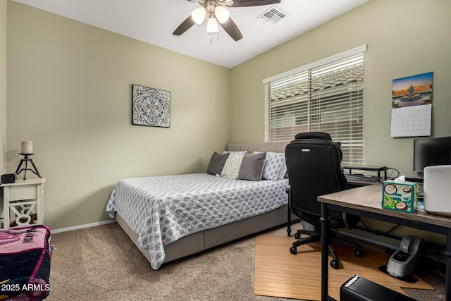 carpeted bedroom with an office area, baseboards, and a ceiling fan