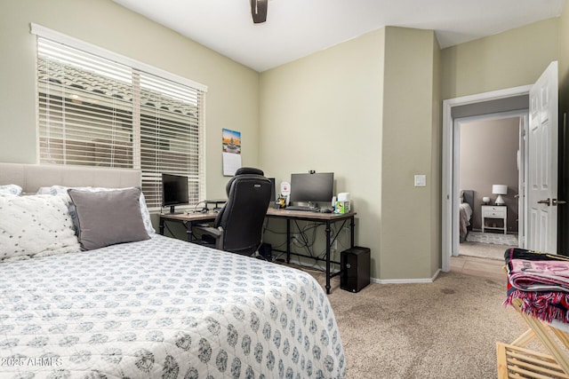 bedroom featuring carpet, baseboards, an office area, and a ceiling fan