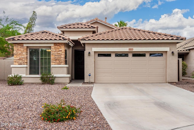 mediterranean / spanish-style home with an attached garage, driveway, stucco siding, and stone siding