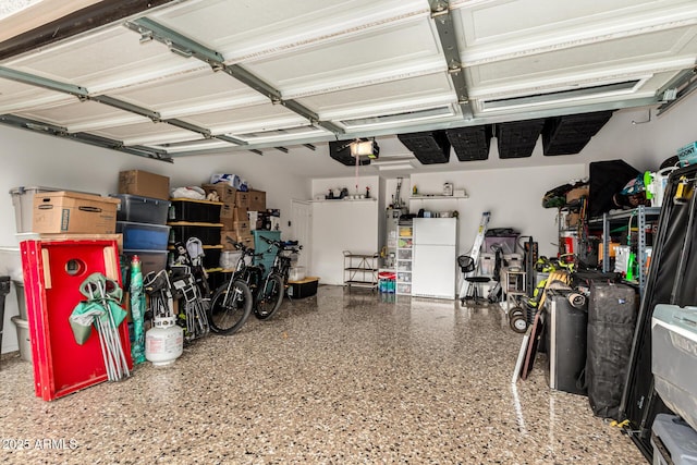 garage with a garage door opener, freestanding refrigerator, and gas water heater