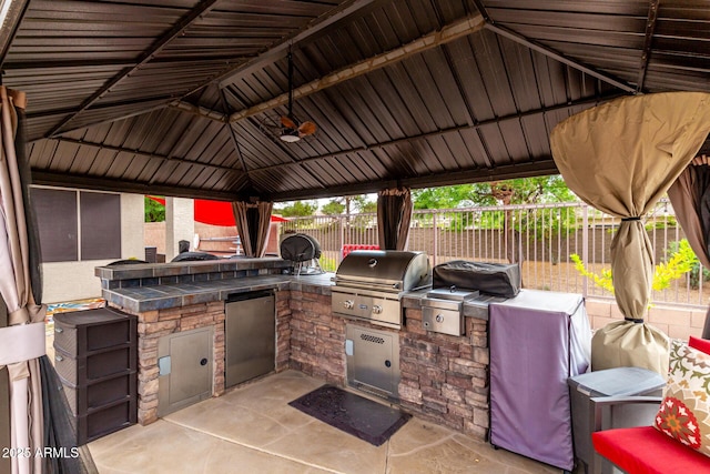 view of patio featuring a grill, area for grilling, fence, and a gazebo