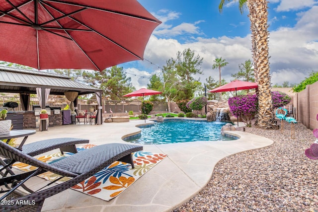 view of swimming pool featuring a gazebo, a fenced backyard, exterior kitchen, and a patio area