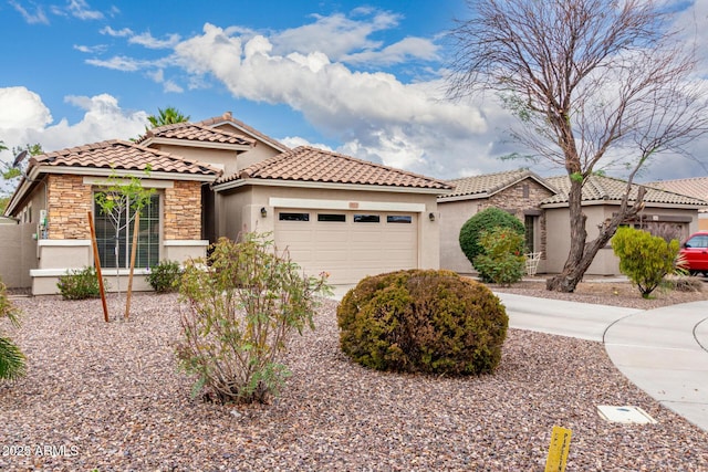 mediterranean / spanish-style house with stucco siding, a garage, a tile roof, and stone siding