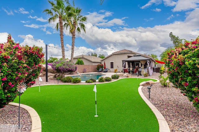 fenced backyard with a gazebo, a putting area, and a patio