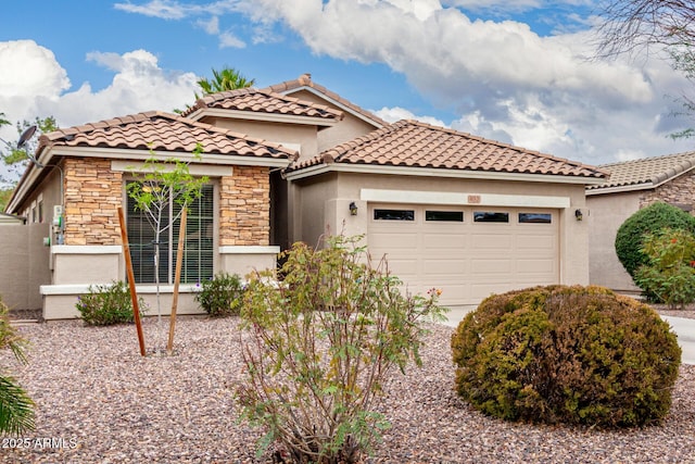 mediterranean / spanish-style house featuring a garage, stone siding, stucco siding, and a tile roof