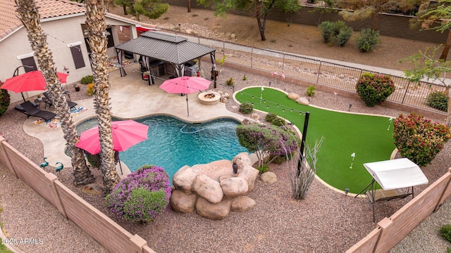 view of swimming pool with a putting area, a gazebo, a patio area, and a fenced backyard