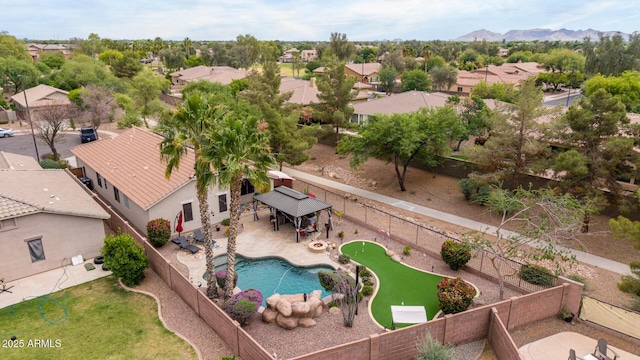 aerial perspective of suburban area with a pool and a mountain backdrop