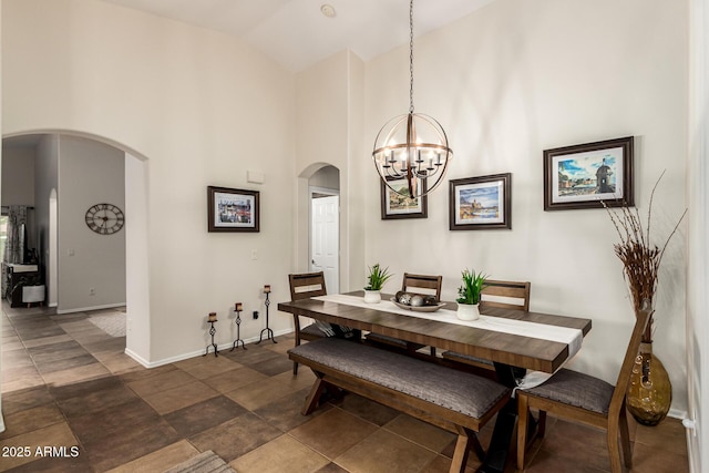 dining room featuring arched walkways, high vaulted ceiling, a chandelier, and baseboards