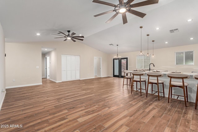 kitchen featuring light countertops, light wood finished floors, visible vents, and a kitchen breakfast bar