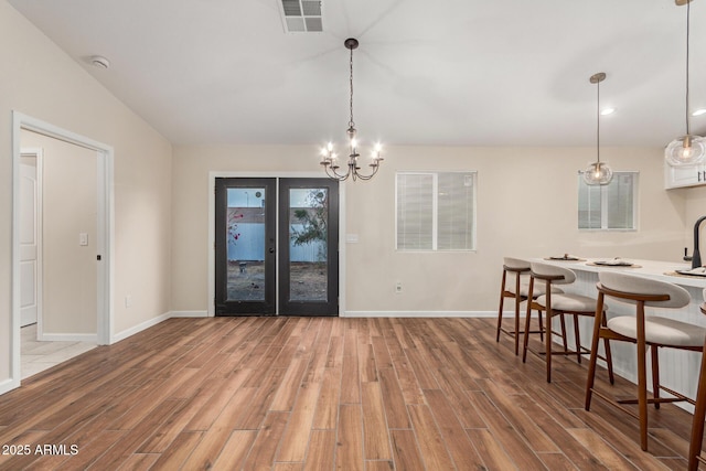 dining area featuring baseboards, visible vents, wood finished floors, and french doors