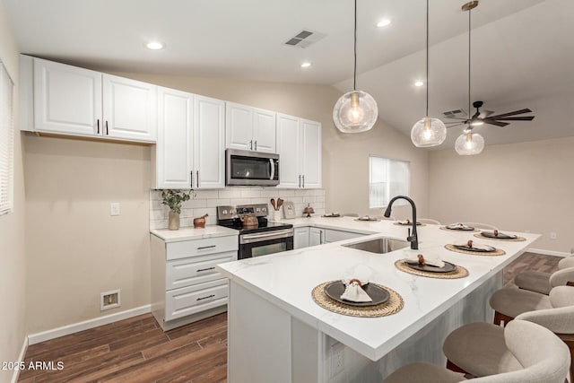 kitchen featuring a breakfast bar, tasteful backsplash, visible vents, appliances with stainless steel finishes, and a sink