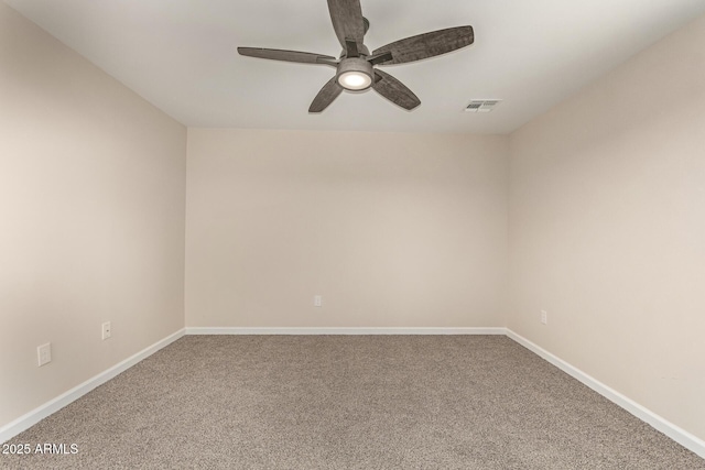 carpeted empty room with baseboards, visible vents, and a ceiling fan