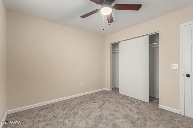 unfurnished bedroom featuring carpet floors, ceiling fan, baseboards, and a closet