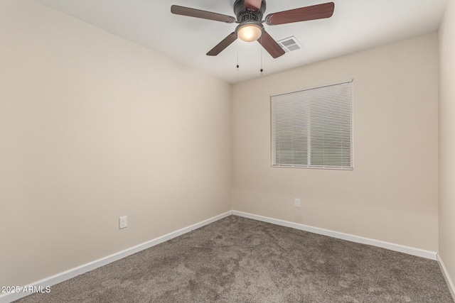 carpeted spare room with a ceiling fan, visible vents, and baseboards