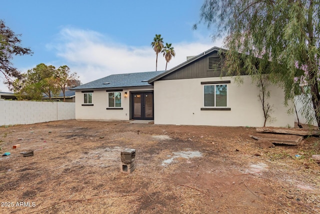 back of house with french doors, a shingled roof, fence, and stucco siding