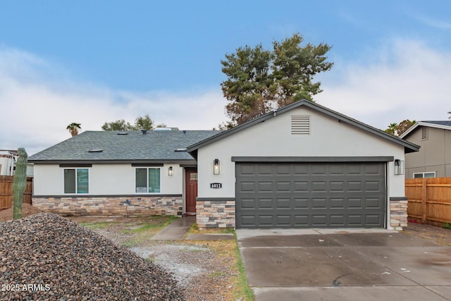 single story home with a garage, fence, concrete driveway, stone siding, and stucco siding