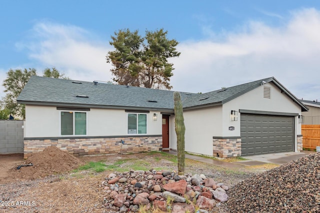 ranch-style house featuring roof with shingles, stucco siding, fence, a garage, and stone siding