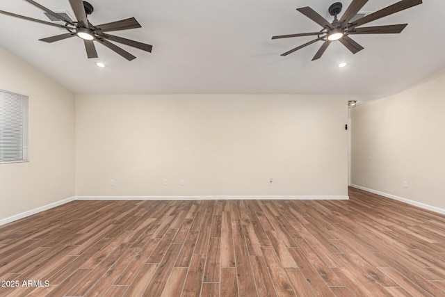 spare room with recessed lighting, wood finished floors, a ceiling fan, and baseboards