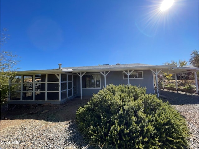 back of house with a sunroom and a carport