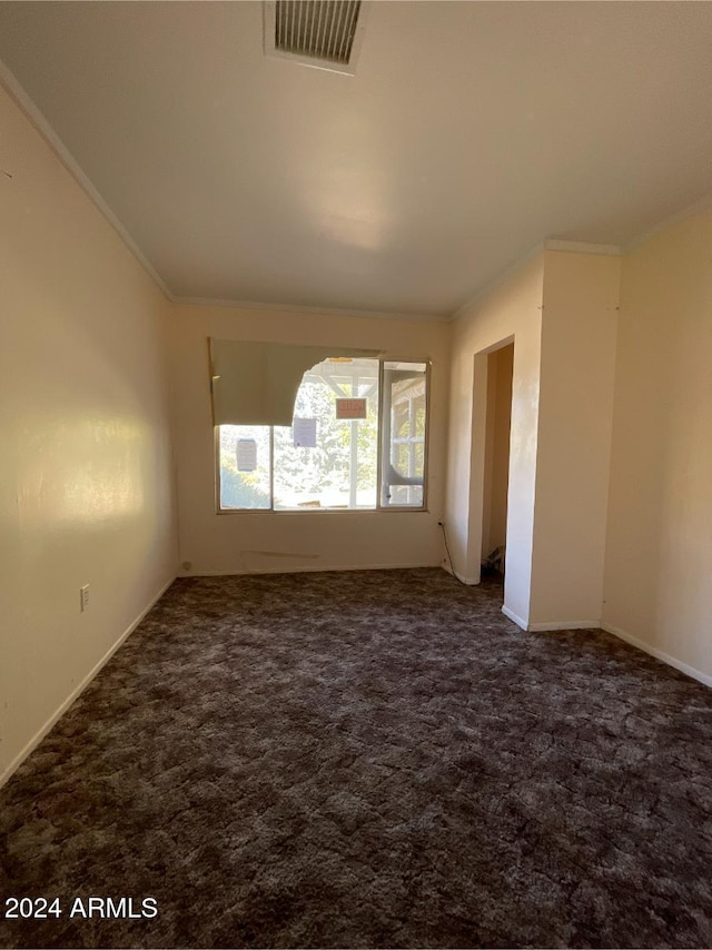 spare room with dark colored carpet and crown molding