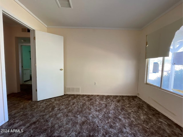 empty room with dark carpet and ornamental molding