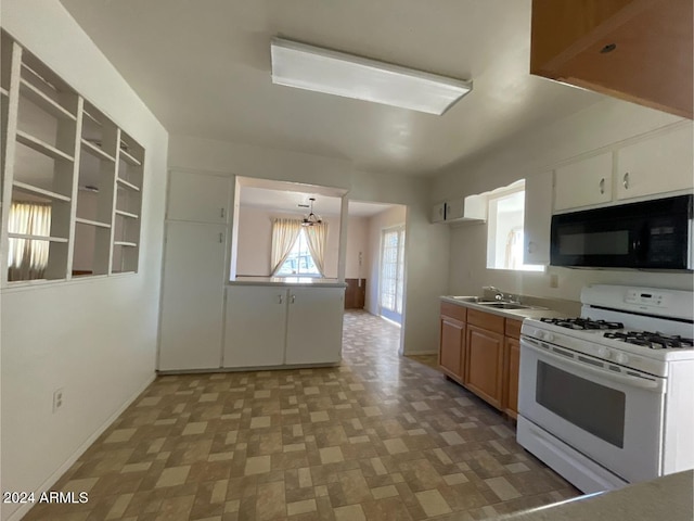 kitchen with sink, white cabinetry, hanging light fixtures, and gas range gas stove