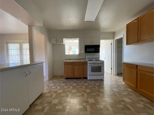 kitchen with plenty of natural light, white gas range, and sink