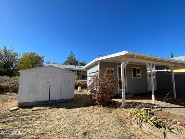 rear view of house with a carport and a storage shed