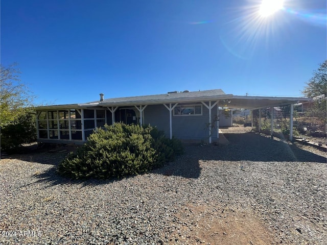 rear view of property with a carport and a sunroom